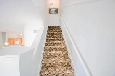 a staircase in a house with white walls and carpeted floors at Berkley Lake Townhomes in Kissimmee