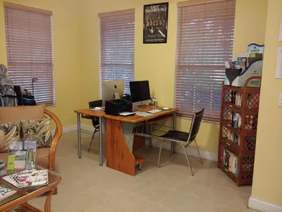 a room with a desk with a computer and chairs at Berkley Lake Townhomes in Kissimmee