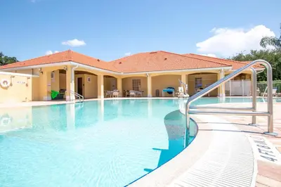 a swimming pool in front of a house at Berkley Lake Townhomes in Kissimmee