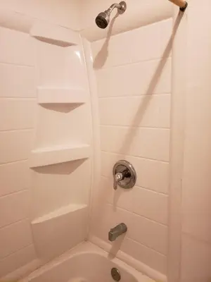 a bathroom with a shower with a white tub at Knights Inn Kissimmee in Kissimmee