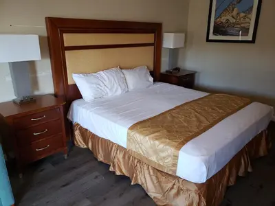 a bed in a hotel room with two nightstands and a bed sidx sidx at Knights Inn Kissimmee in Kissimmee