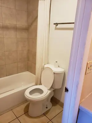 a bathroom with a white toilet and a bath tub at Knights Inn Kissimmee in Kissimmee