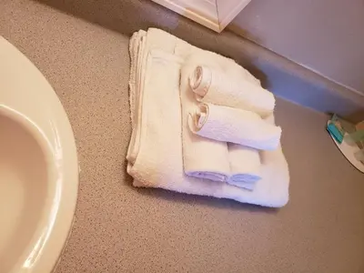 a pile of towels on a bathroom floor next to a sink at Knights Inn Kissimmee in Kissimmee