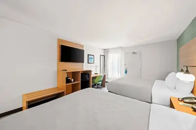 a hotel room with two beds and a desk at Quality Inn Orlando Near International Drive in Orlando