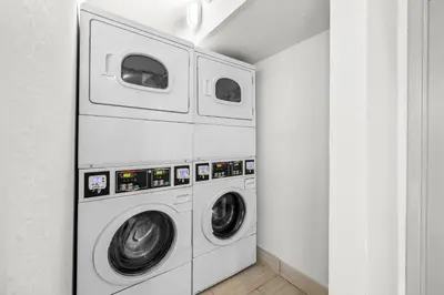 two washing machines in a white laundry room at Quality Inn Orlando Near International Drive in Orlando