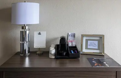 a desk with a lamp and a phone and a picture at Palazzo Lakeside Hotel in Kissimmee