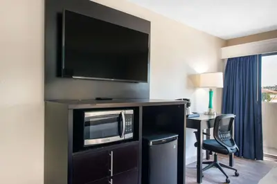 a hotel room with a television and a desk with a chair at Palazzo Lakeside Hotel in Kissimmee