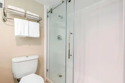 a white bathroom with a shower and a toilet at Palazzo Lakeside Hotel in Kissimmee