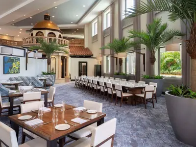 a restaurant with tables and chairs and palm trees at Caribe Royale Orlando in Orlando