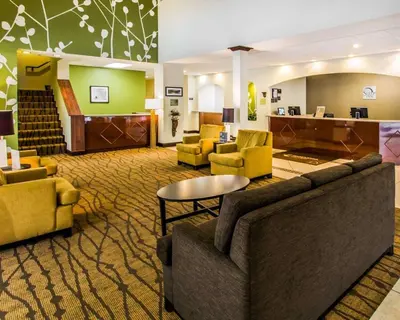 a hotel lobby with couches and chairs and a table at Sleep Inn & Suites Orlando International Airport in Orlando