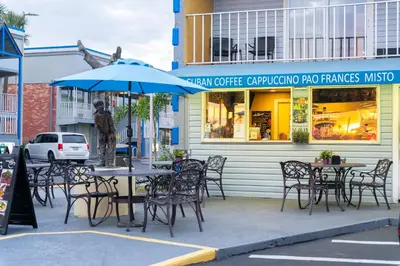 a cafe with tables and chairs and a blue umbrella at Celebration Suites in Orlando