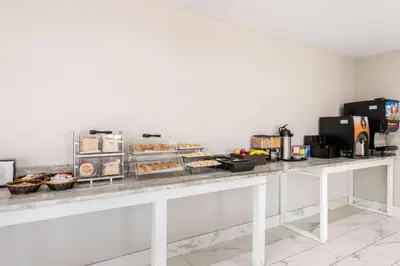 a buffet line with pastries and other food items at Clarion Inn & Suites Kissimmee-Lake Buena Vista South in Kissimmee