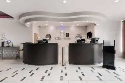a lobby with two reception desks and a sign on the wall at Clarion Inn & Suites Across From Universal Orlando Resort in Orlando