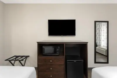 a living room with a tv and a microwave at Days Inn by Wyndham Orlando Conv. Center/International Dr in Orlando