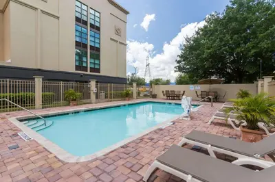 a swimming pool with chairs and a building at Wingate by Wyndham, Universal Studios - Free Theme Park Shuttle in Orlando