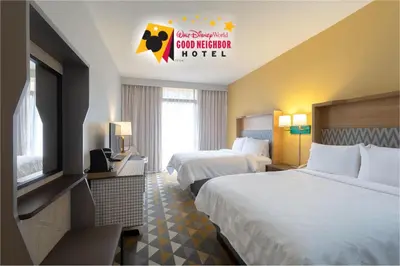 a hotel room with two beds and a television at Holiday Inn & Suites Orlando SW - Celebration Area by IHG in Orlando