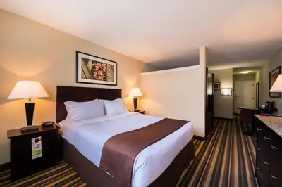a hotel room with a large bed and a kitchen at Holiday Inn & Suites Orlando SW - Celebration Area by IHG in Orlando