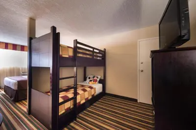 a bedroom with two bunk beds and a flat screen tv at Holiday Inn & Suites Orlando SW - Celebration Area by IHG in Orlando