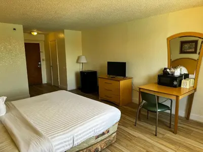 a hotel room with a bed and a desk with a computer at Monumental Movieland Hotel in Orlando
