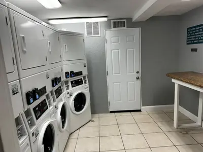 a laundry room with a washer and dryer at Monumental Movieland Hotel in Orlando