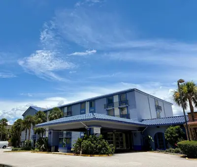 a blue building with palm trees in front of it at Monumental Movieland Hotel in Orlando