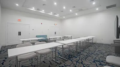 a room with rows of tables and chairs in it at DASKK Orlando Hotel near Universal Blvd, an Ascend Collection Hotel in Orlando