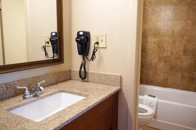 a bathroom with a sink and a phone on the wall at Rosen Inn International Near The Parks in Orlando