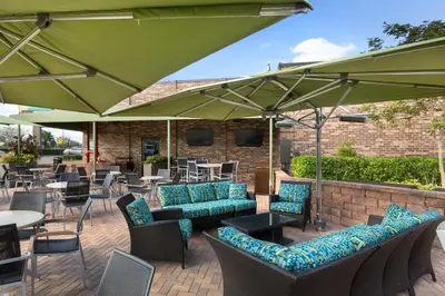 a patio with chairs and tables and umbrellas at Rosen Inn International Near The Parks in Orlando
