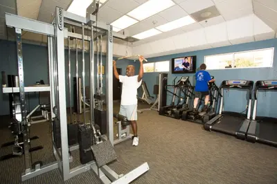 a woman is exercising in a gym at Rosen Inn International Near The Parks in Orlando