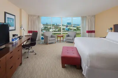 a hotel room with a large bed and a desk with a television at Four Points by Sheraton Orlando International Drive in Orlando