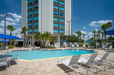 a swimming pool with chairs and a building at Four Points by Sheraton Orlando International Drive in Orlando