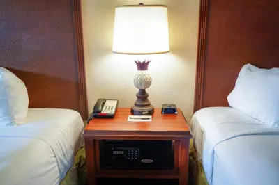 a lamp on a table between two beds in a hotel room at Rosen Inn at Pointe Orlando in Orlando