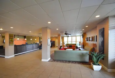 a lobby of a hospital with a person sitting on a couch at Rosen Inn Closest to Universal in Orlando