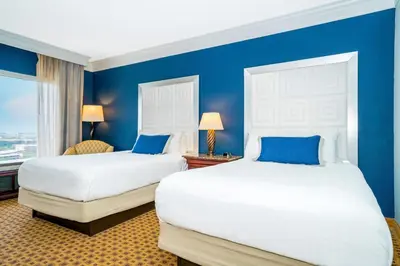 two beds in a room with blue walls at Rosen Plaza Hotel Orlando Convention Center in Orlando