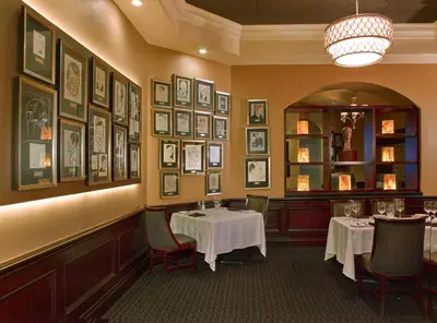 a dining room with two tables and pictures on the walls at Rosen Plaza Hotel Orlando Convention Center in Orlando