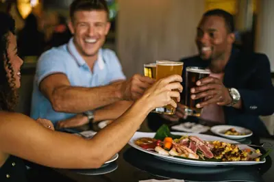 a group of people sitting around a table drinking beer at Rosen Plaza Hotel Orlando Convention Center in Orlando