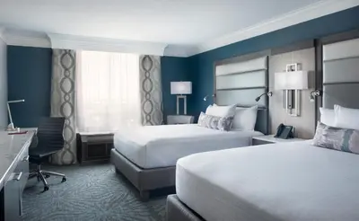 a hotel room with two beds and a desk at Rosen Centre Hotel Orlando Convention Center in Orlando