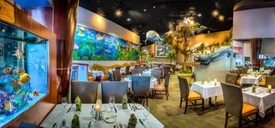 a dining room with tables and chairs in a restaurant at Rosen Centre Hotel Orlando Convention Center in Orlando