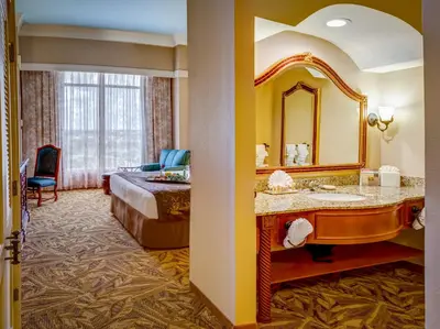a hotel room with a bed and a sink and a mirror at Rosen Shingle Creek Universal Blvd in Orlando