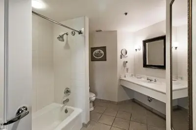a bathroom with a tub and a sink and a toilet at Monumental Hotel Orlando in Orlando
