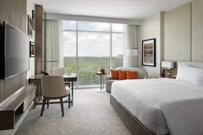 a hotel room with a large bed and a desk and a bedroom at JW Marriott Orlando Bonnet Creek Resort & Spa in Orlando