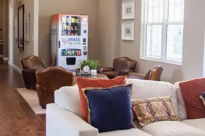 a living room with a couch and chairs and a refrigerator at Amazing townhouse fits 10 in gated community 10 min to Disney! in Kissimmee