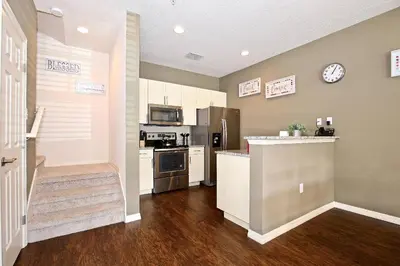 a kitchen with white cabinets and a counter top at 3 Bedroom townhouse fits 8, 10' to Disney parks! in Kissimmee