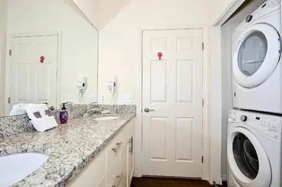 a white bathroom with a washing machine and a sink at 3 Bedroom townhouse fits 8, 10' to Disney parks! in Kissimmee