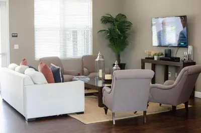 a living room with a couch and a table and chairs at 3 Bedroom townhouse in luxury Resort, sleeps 8, 10 min to Disney! in Kissimmee