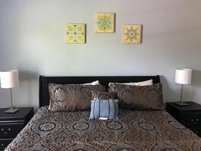 a bed with two lamps and a backpack on it at 3 Bedroom townhouse in luxury Resort, sleeps 8, 10 min to Disney! in Kissimmee