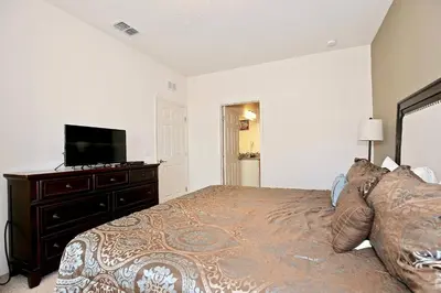 a bedroom with a bed and a flat screen tv at Luxury 3 bedroom townhouse, comfortable sleeps 8 Super close to Disney! in Kissimmee