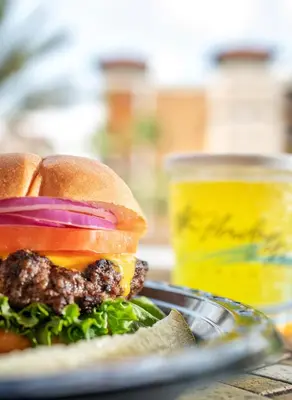 a hamburger on a plate with a jar of mustard at Floridays Orlando Two & Three Bed Rooms Condo Resort in Orlando