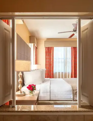 a bedroom with a bed and a table with flowers at Floridays Orlando Two & Three Bed Rooms Condo Resort in Orlando