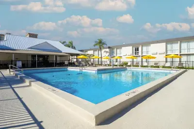 a swimming pool at a hotel with yellow umbrellas at B&B HOTEL Orlando International Drive near Universal - Newly Renovated! in Orlando